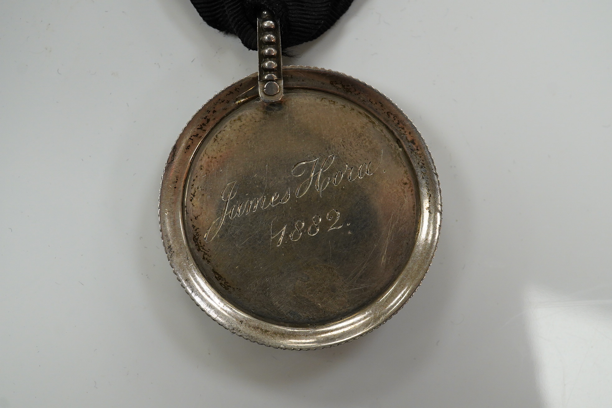 A Worshipful Company of Vintners silver badge, named for James Hora, 1882